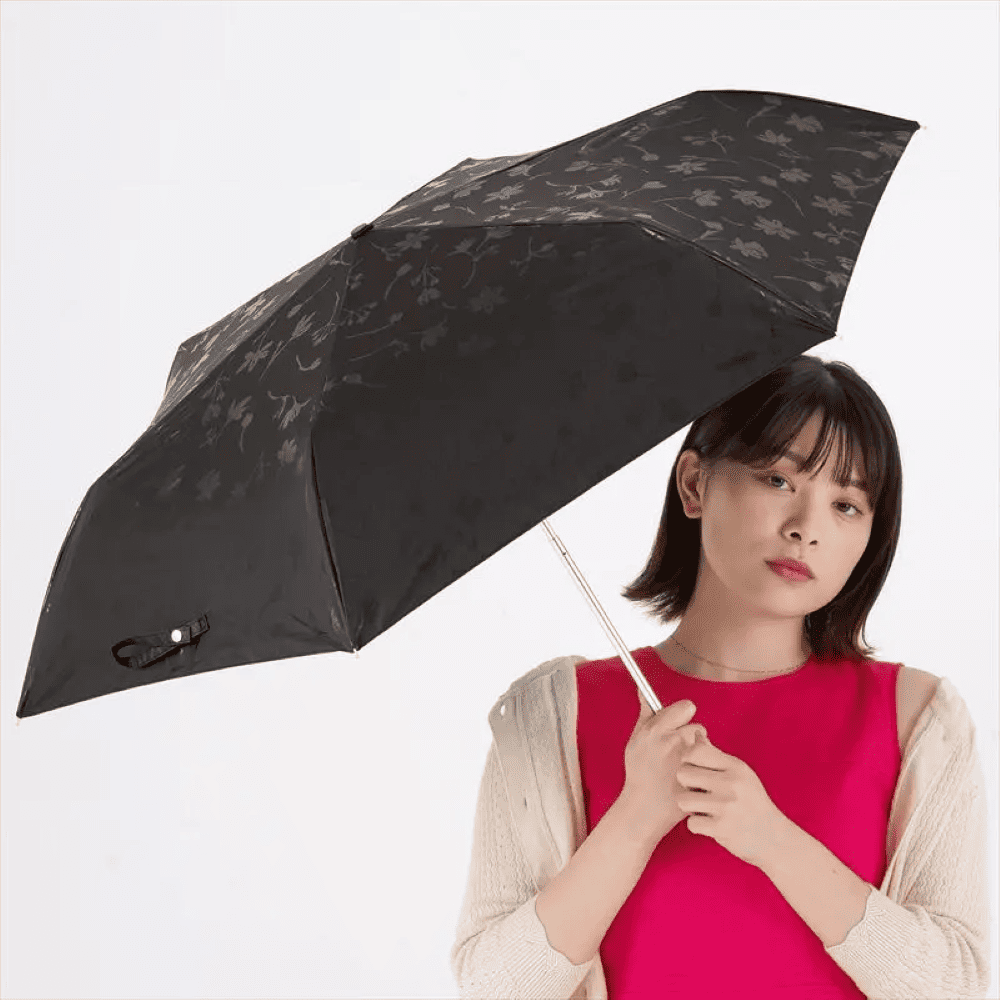 黒色折りたたみ傘を差す女性